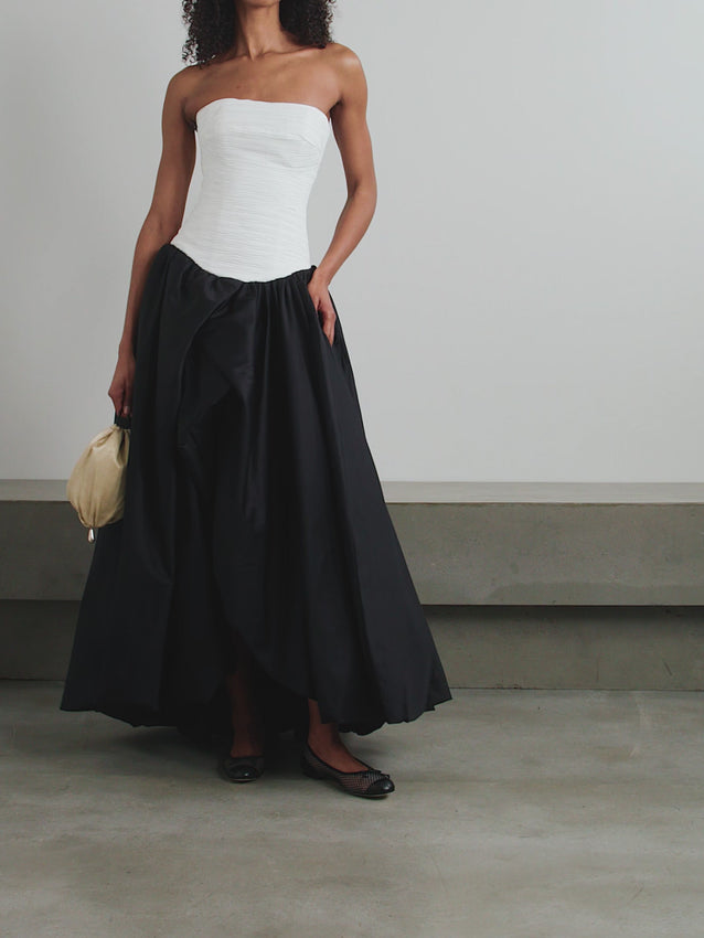 Command attention with the Violette Bubble Hem Maxi Dress, a sophisticated statement piece that seamlessly blends architectural design with effortless glamour. The expertly ruched fitted bodice creates a flattering silhouette, while the signature asymmetrical bubble hem delivers unexpected drama and movement. Crafted in pure cotton for breathable comfort, this strapless gown transitions beautifully from evening events to refined occasions. 