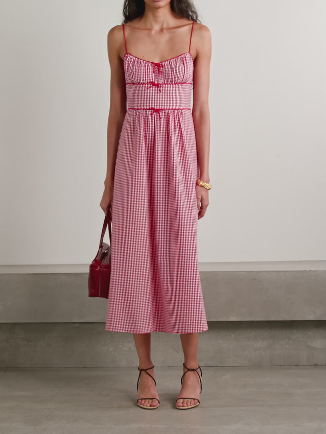 The Belline Midi Dress combines timeless style with sustainable craftsmanship. Crafted from lightweight recycled-seersucker blended with cotton, this piece features a classic gingham check pattern that never goes out of style. The gently gathered bodice is adorned with delicate bows, creating an effortlessly charming silhouette perfect for warm weather occasions. Breathable and beautifully detailed, it's a versatile addition to any wardrobe.
