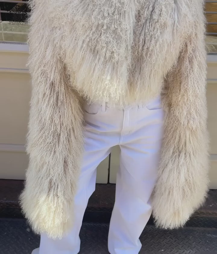 The Hannah Shearling Cape Coat in Beige blends luxurious lama fur with a unique, cropped design that adds elegant volume through its cape-like sleeves. Equipped with hidden zippers, it offers versatile styling options—transition effortlessly from a structured look to a relaxed silhouette. This coat is the perfect choice for anyone aiming to make a sophisticated and unforgettable impression.