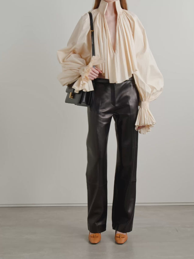 The Durer blouse channels vintage elegance through its meticulously gathered silhouette. High neckline and tapered sleeves feature intricate pleating that creates dramatic volume and movement. Crafted from a refined cotton-blend poplin, this cropped style balances structure with fluidity. The plunging neckline adds contemporary sophistication to its timeless design—perfect for layering or wearing as a statement piece.