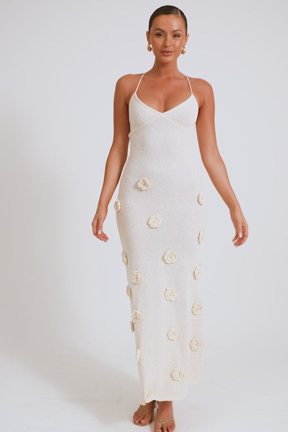 Elevate your wardrobe with the Suki Crochet Maxi Dress, a timeless piece that combines elegance with everyday wearability. The V neckline and crisscross straps frame the body beautifully, while the fitted silhouette celebrates your natural curves with confidence. This unlined knit dress features hand-crafted flower appliqués that bring dimension and artistry to every wear. 