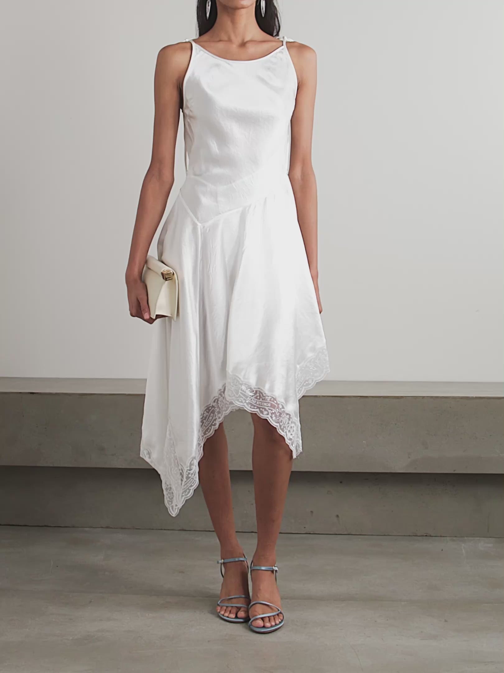Cut on the bias from luminous white satin with a subtle hammered finish, the Doyla Hammered-satin Midi Dress by Acne Studios exudes effortless elegance. Its adjustable straps and self-tie belt let you tailor the fit to highlight your waist, while the asymmetric hem trimmed with delicate lace adds a touch of feminine allure. Perfect for making a refined statement, this dress beautifully captures light and movement for standout sophistication.