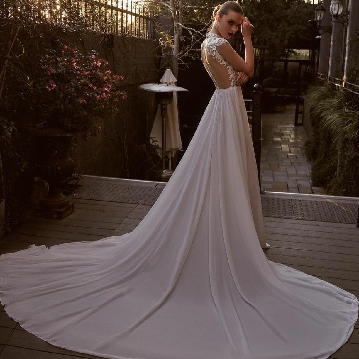 Enhance your special day with the luxurious Robe Lian. This exquisite Wedding Dress features a jewel neckline, delicate lace appliques, and elegant cap sleeves, all crafted with the finest chiffon fabric. The sweeping train and custom fit make this Boho-inspired dress a must-have for the sophisticated bride.