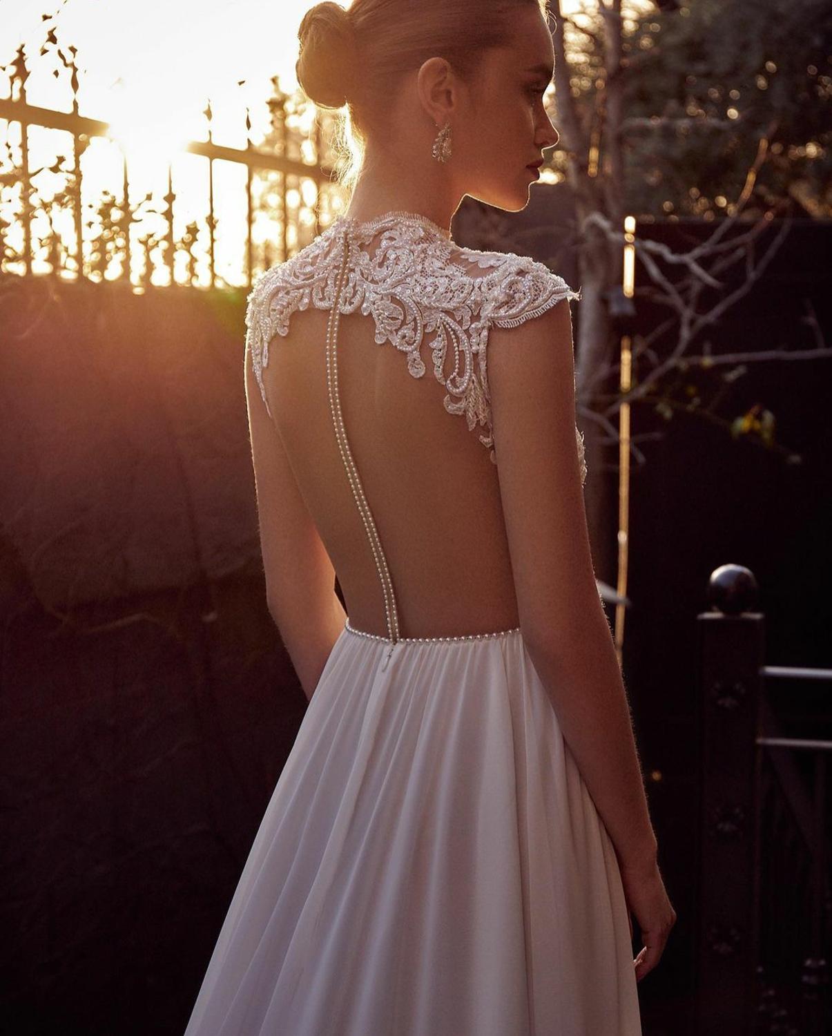 Enhance your special day with the luxurious Robe Lian. This exquisite Wedding Dress features a jewel neckline, delicate lace appliques, and elegant cap sleeves, all crafted with the finest chiffon fabric. The sweeping train and custom fit make this Boho-inspired dress a must-have for the sophisticated bride.