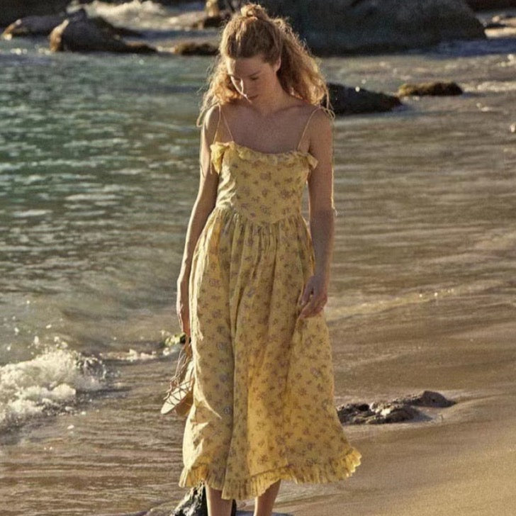 Indulge in the elegance of the Wendelin Midi Dress by Dôen. This beautiful cotton dress features a charming yellow, brown, and cream floral pattern, along with a flattering v waist and adjustable straps for a perfect fit. The delicate ruffle adds a playful touch to this sophisticated and exclusive sundress.