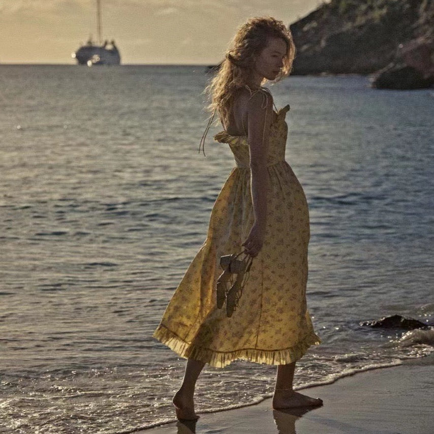 Indulge in the elegance of the Wendelin Midi Dress by Dôen. This beautiful cotton dress features a charming yellow, brown, and cream floral pattern, along with a flattering v waist and adjustable straps for a perfect fit. The delicate ruffle adds a playful touch to this sophisticated and exclusive sundress.